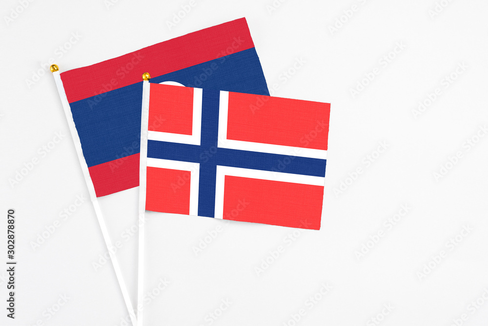 Bouvet Islands and Laos stick flags on white background. High quality fabric, miniature national flag. Peaceful global concept.White floor for copy space.
