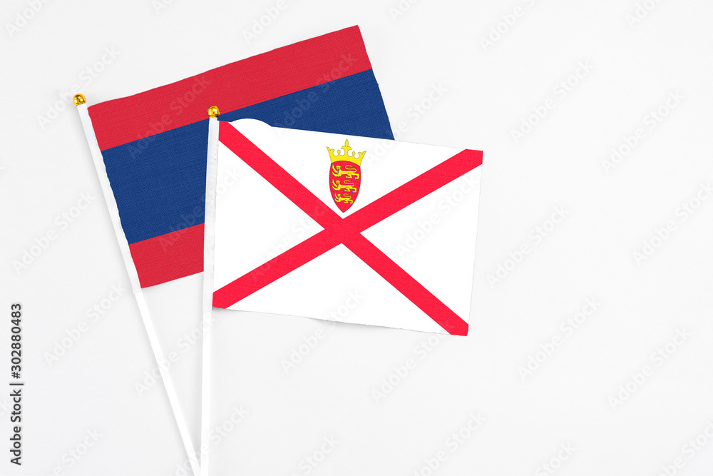 Jersey and Laos stick flags on white background. High quality fabric, miniature national flag. Peaceful global concept.White floor for copy space. Jersey and Laos stick flags on white background. High quality fabric, miniature national flag. Peaceful global concept.White floor for copy space.