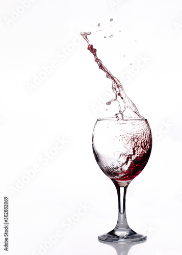 Roter Wein spritzt aus einem Weinglas