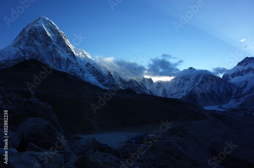 Everest base camp trek along Khumbu glacier, First sun is touching Pumo Ri (7165 m). Gorakshep and Kala Patthar in the morning dusk. Himalayas mountains, Sagarmatha national park, Solukhumbu, Nepal