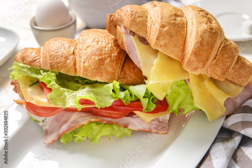 Tasty croissant sandwiches on plate, closeup