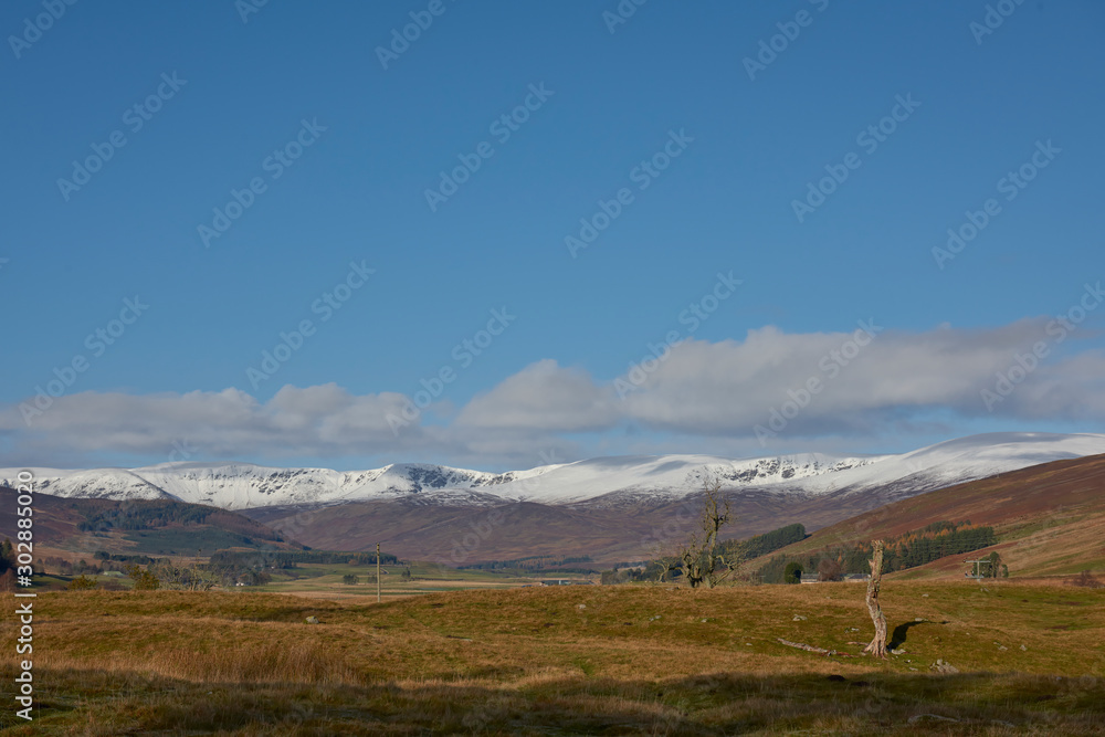 Looking west along the Glen Clova Valley towards Corrie Fee, with Snow covering the Tops of the Mountains on a bright November day.