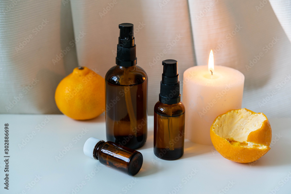 Aromatherapy products - essential oils and candle on white drapery background. Aromatherapy products - essential oils and candle on white drapery background.
