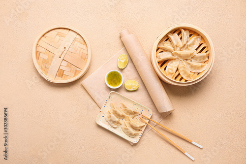 Bamboo steamer with tasty Japanese gyoza on light background