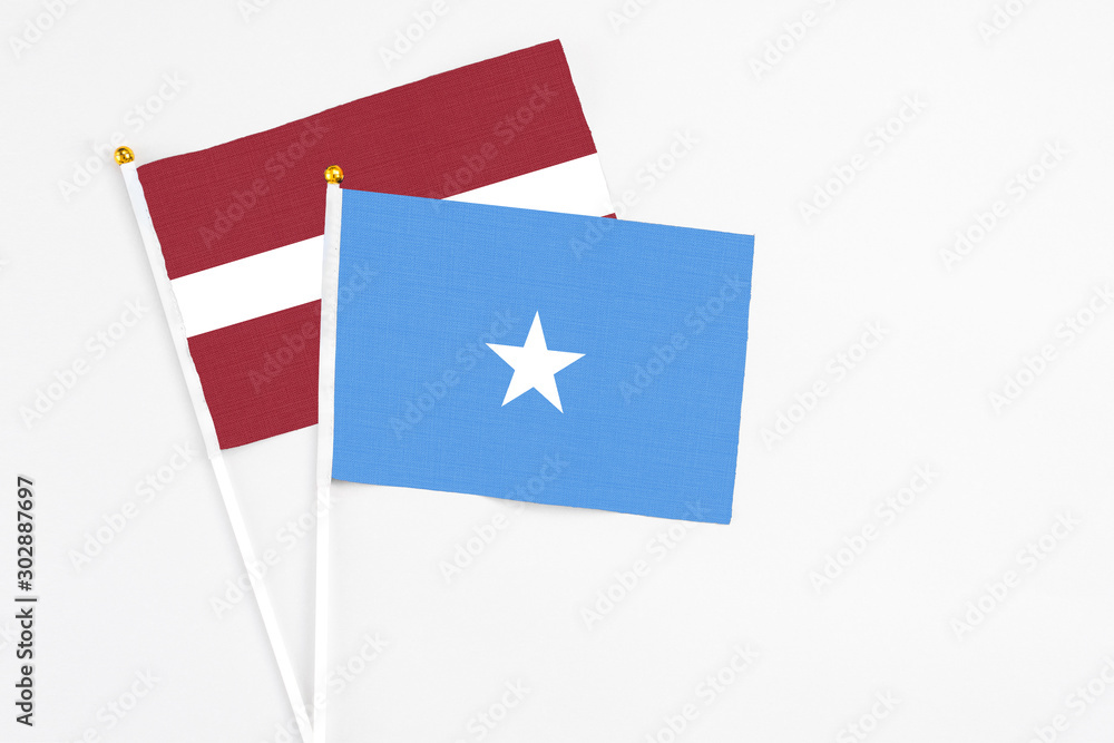 Somalia and Latvia stick flags on white background. High quality fabric, miniature national flag. Peaceful global concept.White floor for copy space. Somalia and Latvia stick flags on white background. High quality fabric, miniature national flag. Peaceful global concept.White floor for copy space.