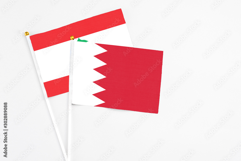 Bahrain and Lebanon stick flags on white background. High quality fabric, miniature national flag. Peaceful global concept.White floor for copy space. Bahrain and Lebanon stick flags on white background. High quality fabric, miniature national flag. Peaceful global concept.White floor for copy space.