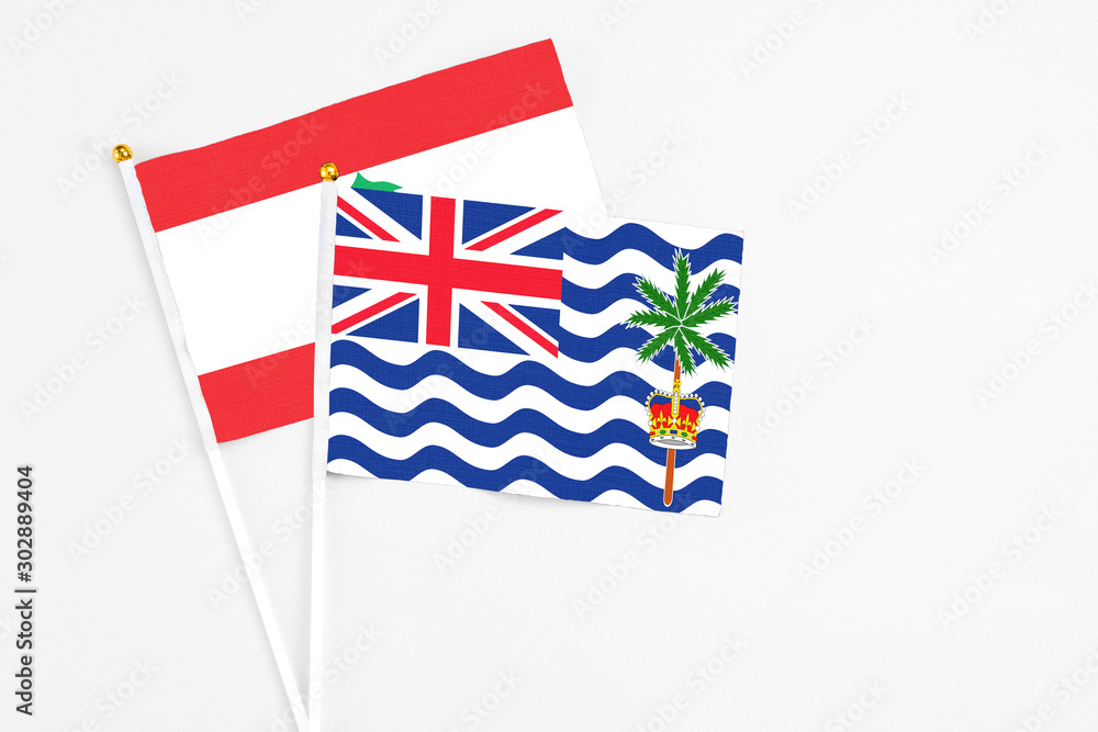 Fototapeta premium British Indian Ocean Territory and Lebanon stick flags on white background. High quality fabric, miniature national flag. Peaceful global concept.White floor for copy space.