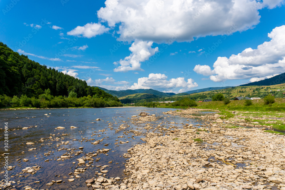 Sunny summer day and mountain river with stones