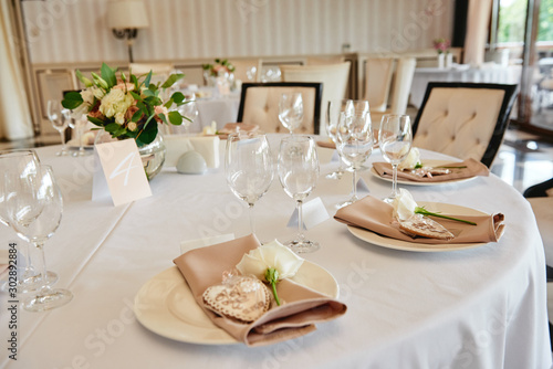 Table setting with sparkling wineglasses and cutlery on table, copy space. Menu mockup, place setting at wedding reception. Table served for wedding banquet in restaurant © mirage_studio