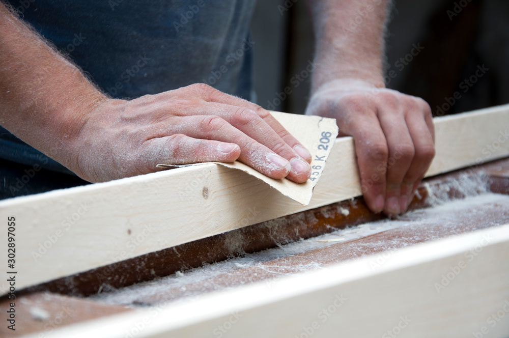 carpenter polishes wood with sandpaper - obrazy, fototapety, plakaty 