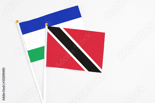 Trinidad And Tobago and Lesotho stick flags on white background. High quality fabric, miniature national flag. Peaceful global concept.White floor for copy space. Free Download Trinidad And Tobago and Lesotho stick flags on white background. High quality fabric, miniature national flag. Peaceful global concept.White floor for copy space. - GFXLoad