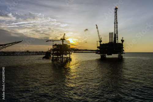 Silhouette of oil production platform during sunset at oil field