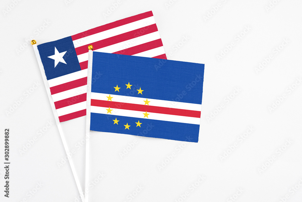 Cape Verde and Liberia stick flags on white background. High quality fabric, miniature national flag. Peaceful global concept.White floor for copy space. Cape Verde and Liberia stick flags on white background. High quality fabric, miniature national flag. Peaceful global concept.White floor for copy space.