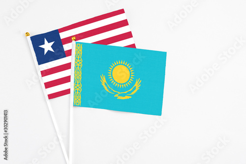 Kazakhstan and Liberia stick flags on white background. High quality fabric, miniature national flag. Peaceful global concept.White floor for copy space.