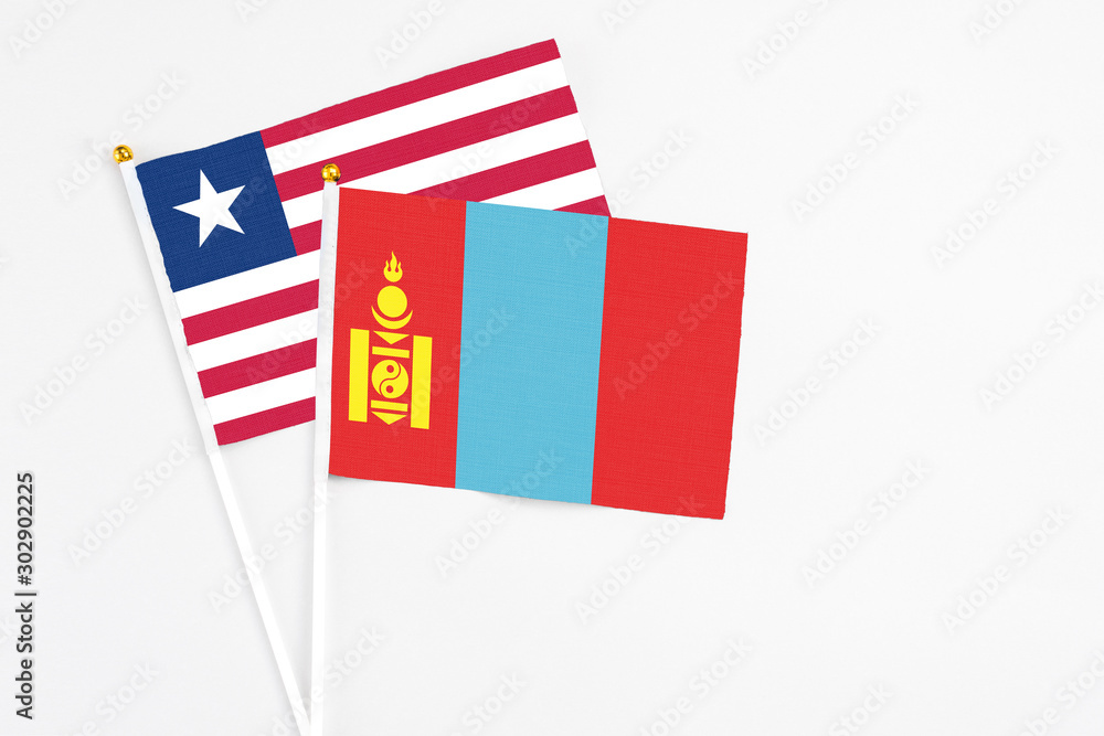 Obraz premium Mongolia and Liberia stick flags on white background. High quality fabric, miniature national flag. Peaceful global concept.White floor for copy space.