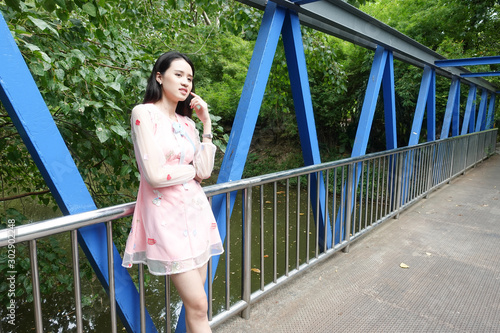 Portrait of young asian woman standing on a bridge