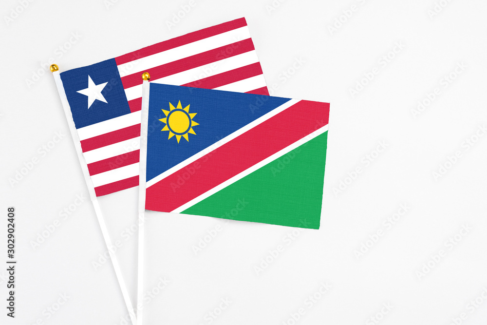 Namibia and Liberia stick flags on white background. High quality fabric, miniature national flag. Peaceful global concept.White floor for copy space. Namibia and Liberia stick flags on white background. High quality fabric, miniature national flag. Peaceful global concept.White floor for copy space.