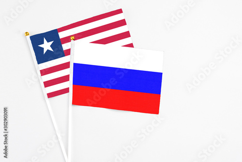 Free Download Russia and Liberia stick flags on white background. High quality fabric, miniature national flag. Peaceful global concept.White floor for copy space. - GFXLoad
