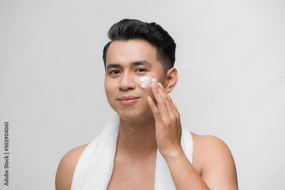 smiling man applying cosmetic cream on face, smiling man applying cosmetic cream on face,