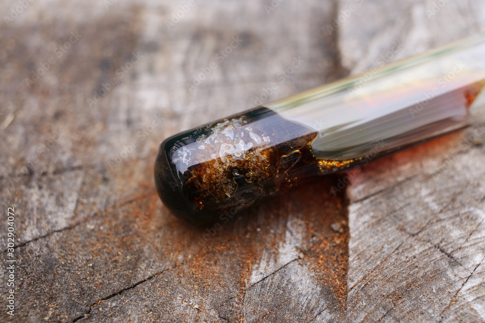 Test tube with a reaction mixture of nitric acid and metallic iron, nitrogen dioxide gas is released. On the surface of a wood. Test tube with a reaction mixture of nitric acid and metallic iron, nitrogen dioxide gas is released. On the surface of a wood.
