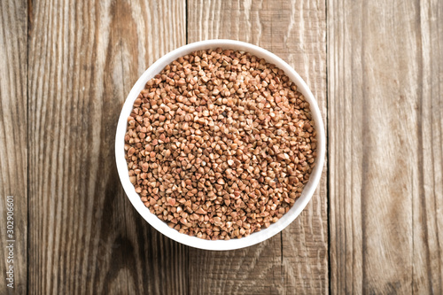 Buckwheat in a light bowl on a rustic background top view copy space.