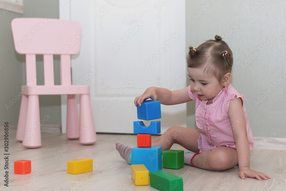 Young kid playing on a floor in a room Young kid playing on a floor in a room
