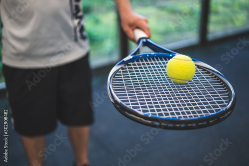 Guy balancing a tennis ball on a racket © Martin