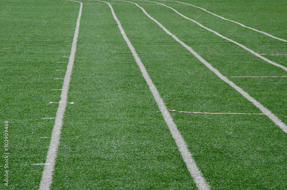 white line as running lane on the green grass
