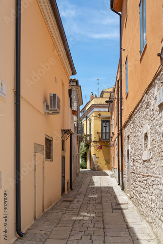 A narrow street among the old houses of a medieval town in Venosa Italy