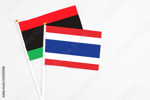 Free Download Thailand and Libya stick flags on white background. High quality fabric, miniature national flag. Peaceful global concept.White floor for copy space. - GFXLoad