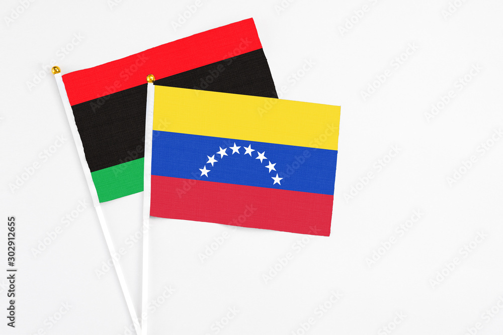 Venezuela and Libya stick flags on white background. High quality fabric, miniature national flag. Peaceful global concept.White floor for copy space. Venezuela and Libya stick flags on white background. High quality fabric, miniature national flag. Peaceful global concept.White floor for copy space.