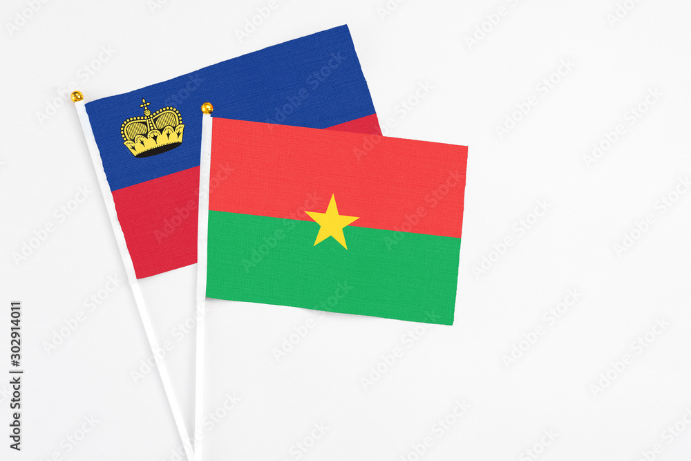 Burkina Faso and Liechtenstein stick flags on white background. High quality fabric, miniature national flag. Peaceful global concept.White floor for copy space. Burkina Faso and Liechtenstein stick flags on white background. High quality fabric, miniature national flag. Peaceful global concept.White floor for copy space.