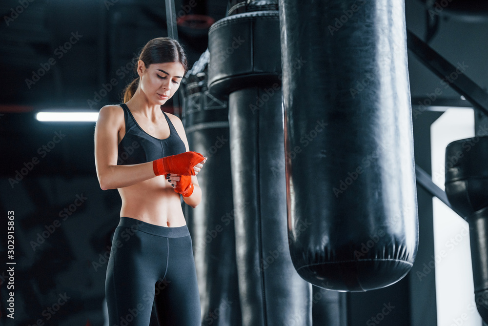Young woman in sportive wear is in the gym having exercise day. Conception of boxing