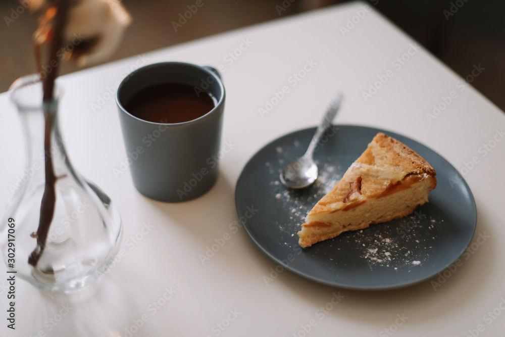 Piece of apple pie on plate with cup of coffee on white table. Breakfast with coffee and cake in cafe. food photography. Piece of apple pie on plate with cup of coffee on white table. Breakfast with coffee and cake in cafe. food photography.