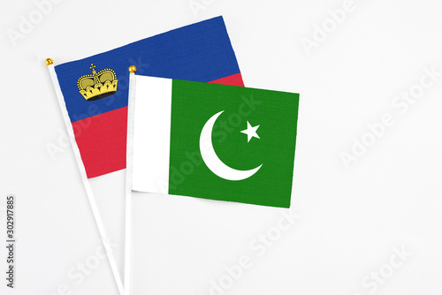Pakistan and Liechtenstein stick flags on white background. High quality fabric, miniature national flag. Peaceful global concept.White floor for copy space.