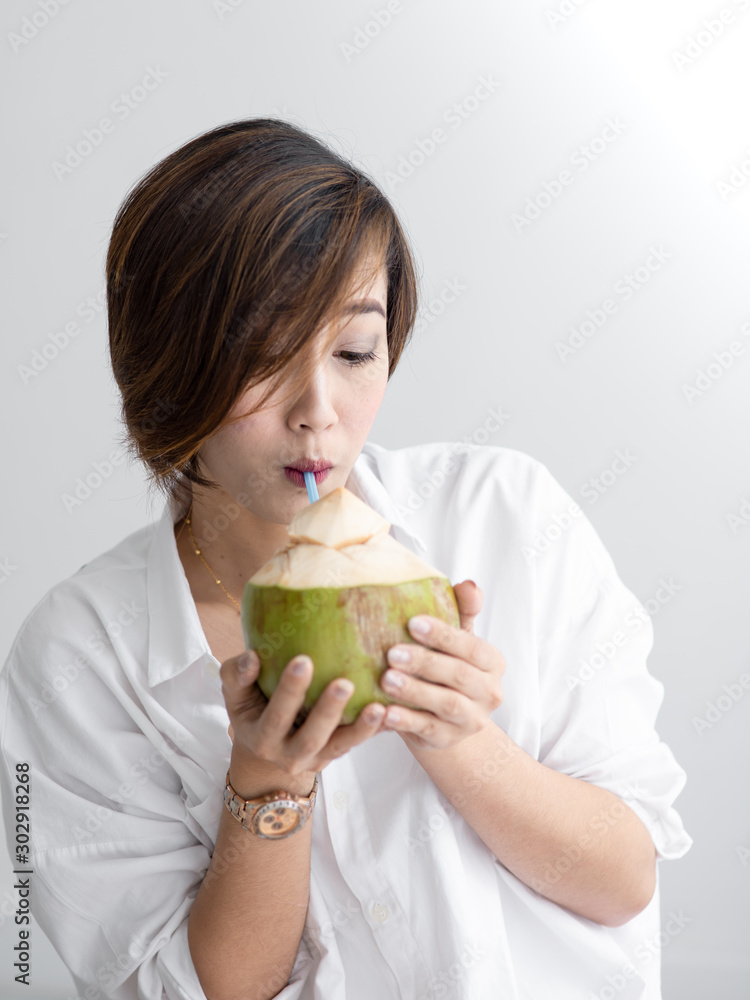 Asian cute girl relax with coconut drink in white room, lifestyle concept. Asian cute girl relax with coconut drink in white room, lifestyle concept.