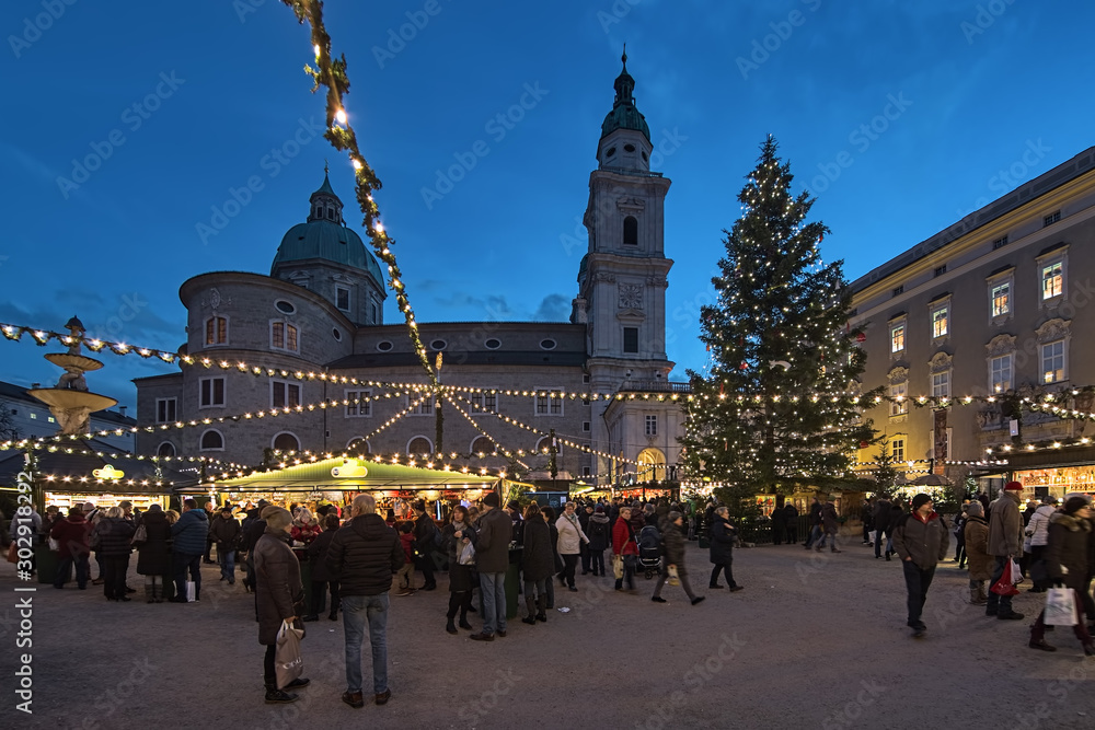 Fototapeta premium Salzburg, Austria. Jarmark bożonarodzeniowy o zmierzchu na placu Residenzplatz w pobliżu katedry w Salzburgu.