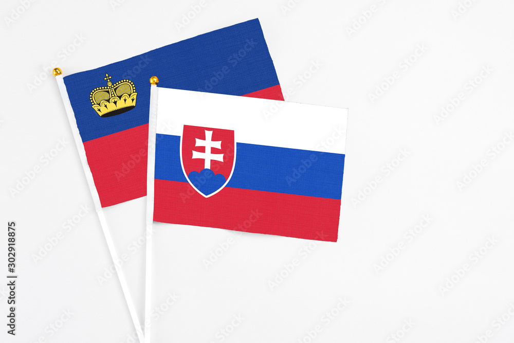 Slovakia and Liechtenstein stick flags on white background. High quality fabric, miniature national flag. Peaceful global concept.White floor for copy space. Slovakia and Liechtenstein stick flags on white background. High quality fabric, miniature national flag. Peaceful global concept.White floor for copy space.
