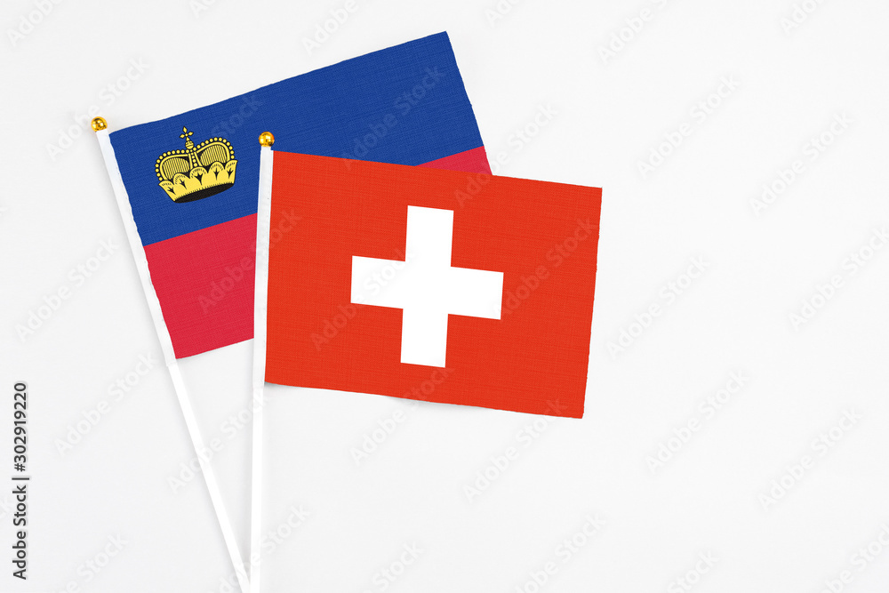 Switzerland and Liechtenstein stick flags on white background. High quality fabric, miniature national flag. Peaceful global concept.White floor for copy space.