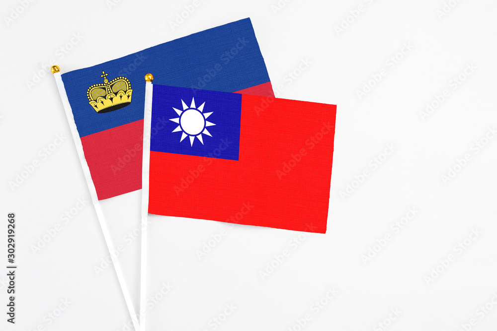 Taiwan and Liechtenstein stick flags on white background. High quality fabric, miniature national flag. Peaceful global concept.White floor for copy space.