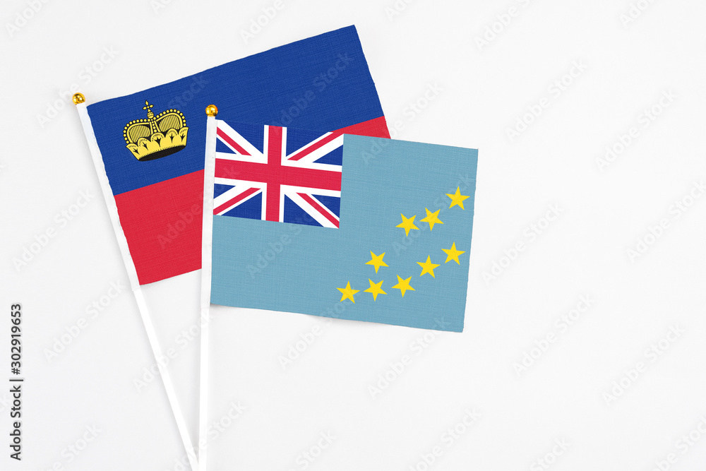 Fototapeta premium Tuvalu and Liechtenstein stick flags on white background. High quality fabric, miniature national flag. Peaceful global concept.White floor for copy space.