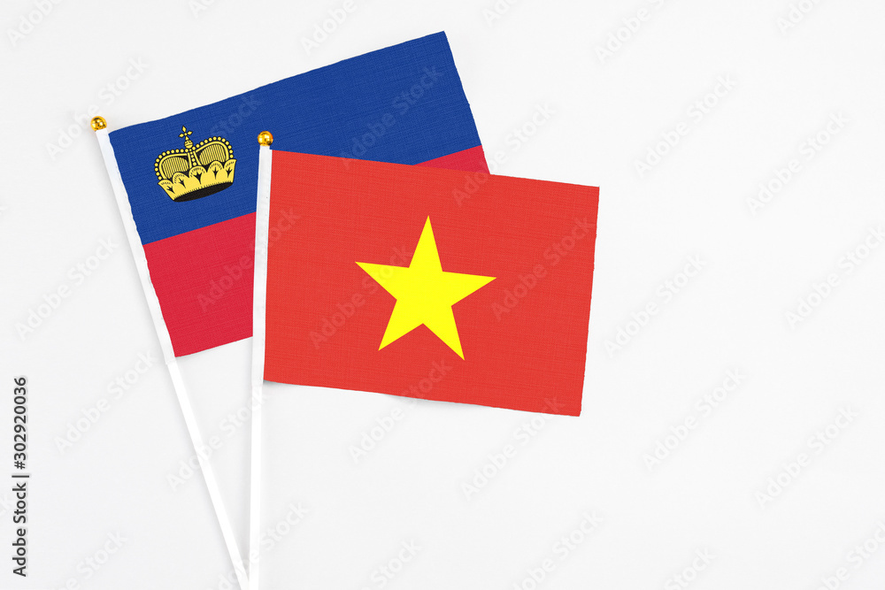 Vietnam and Liechtenstein stick flags on white background. High quality fabric, miniature national flag. Peaceful global concept.White floor for copy space. Vietnam and Liechtenstein stick flags on white background. High quality fabric, miniature national flag. Peaceful global concept.White floor for copy space.