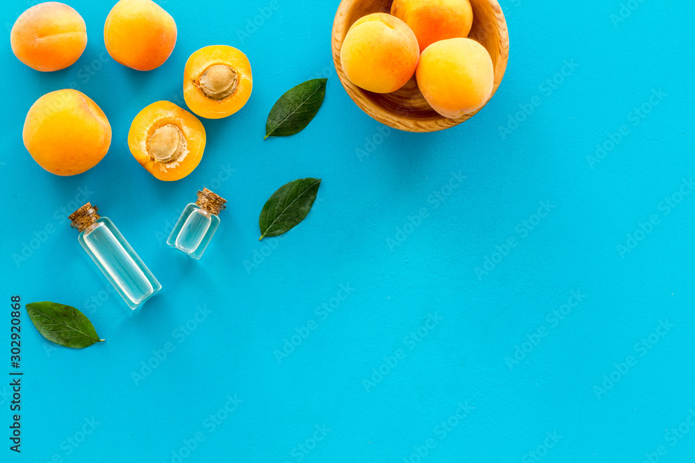 Fruit aroma oil. Apricot kernel oil on blue background top view frame space for text