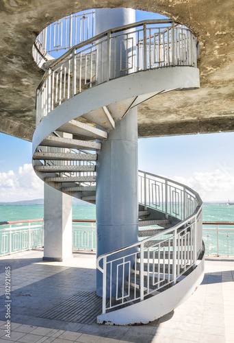 Iron spiral staircase on the background of turquoise sea