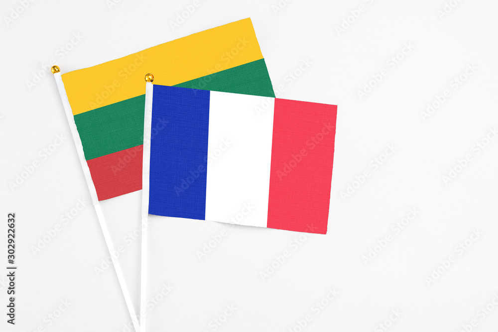 France and Lithuania stick flags on white background. High quality fabric, miniature national flag. Peaceful global concept.White floor for copy space.