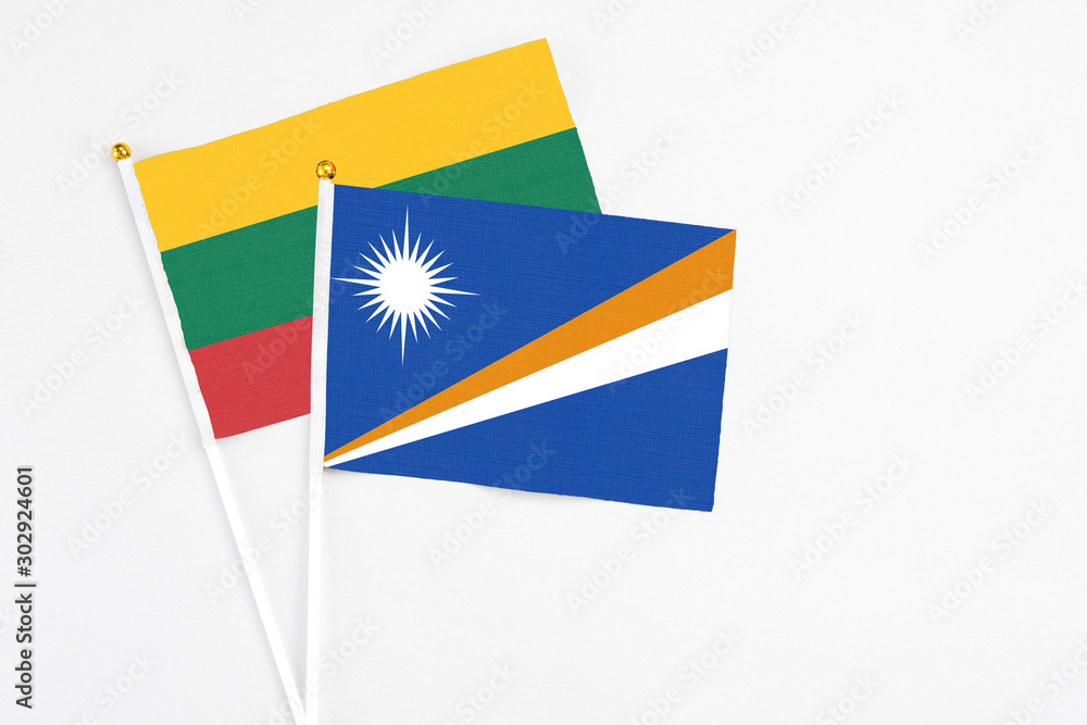 Marshall Islands and Lithuania stick flags on white background. High quality fabric, miniature national flag. Peaceful global concept.White floor for copy space.