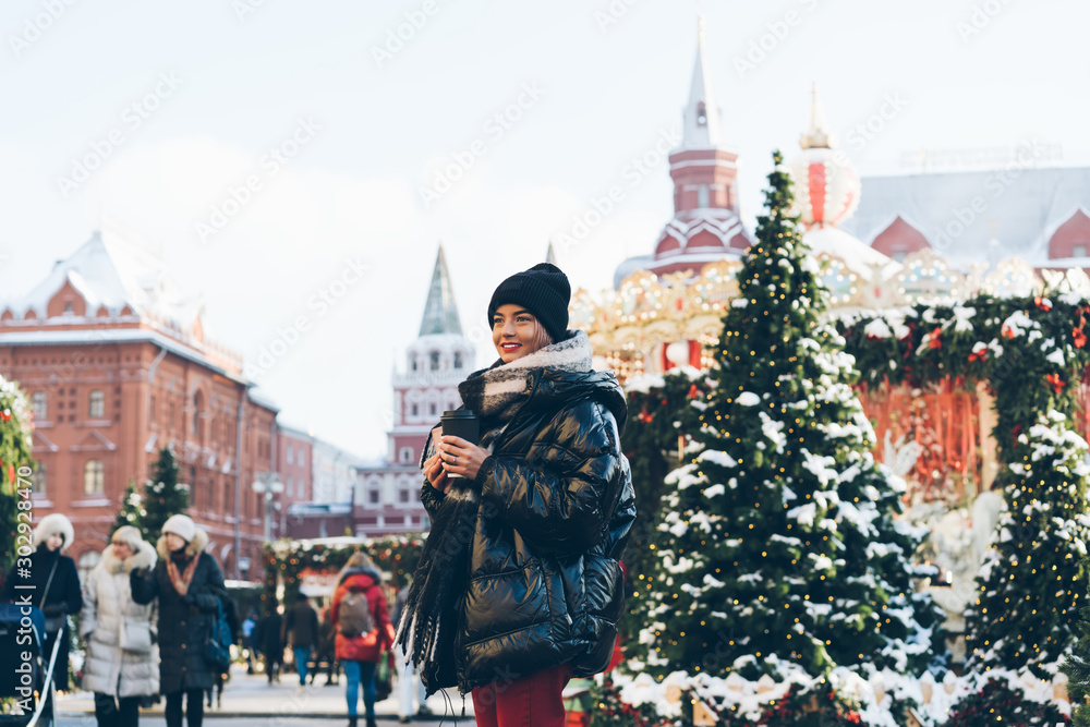 Beautiful woman standing on Red Square decorated with Christmas trees