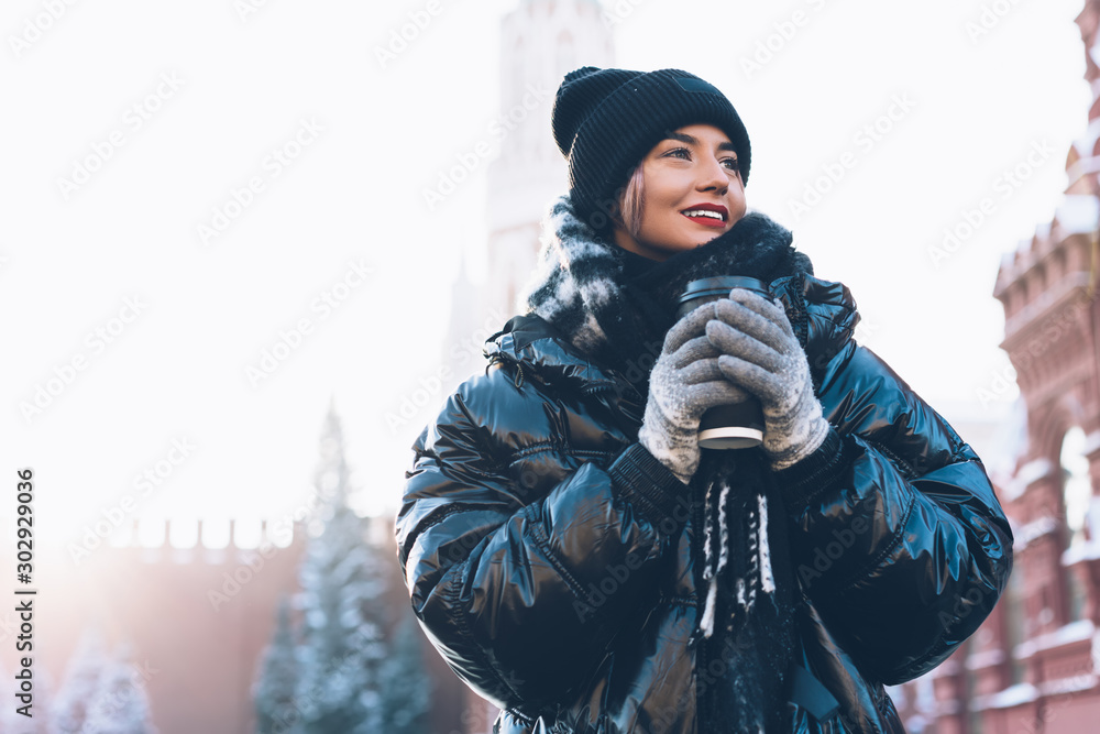 Smiling female in cozy jacket with hot beverage. Stock Photo | Adobe Stock