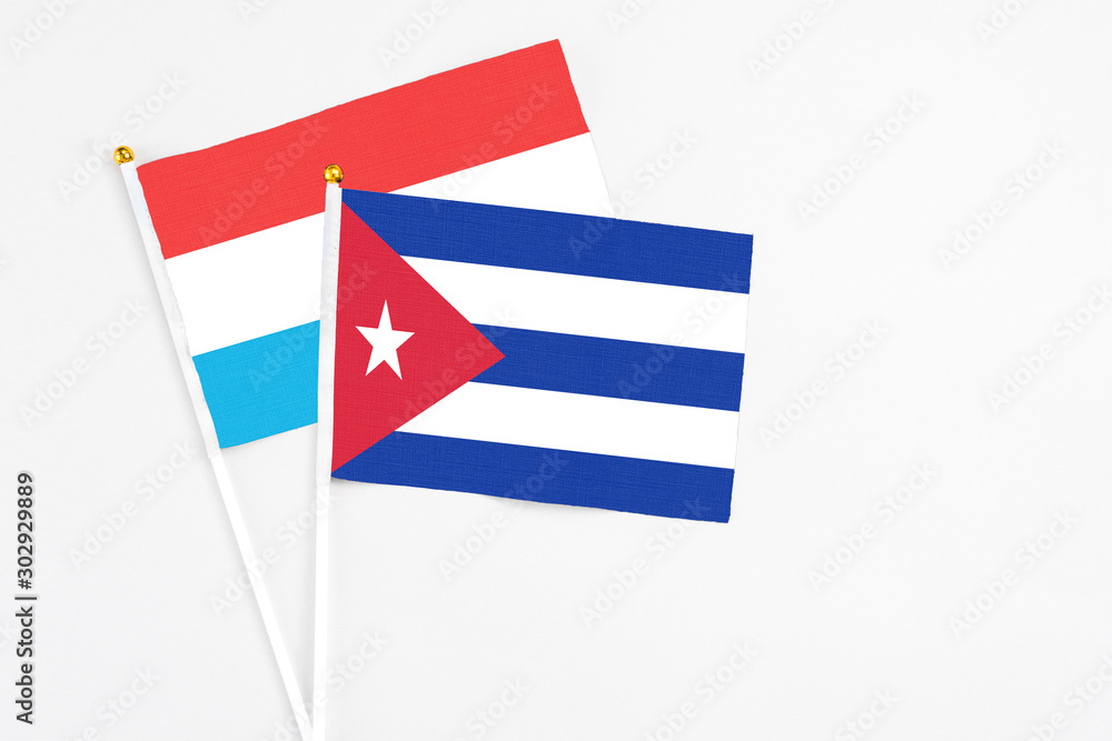 Cuba and Luxembourg stick flags on white background. High quality fabric, miniature national flag. Peaceful global concept.White floor for copy space.