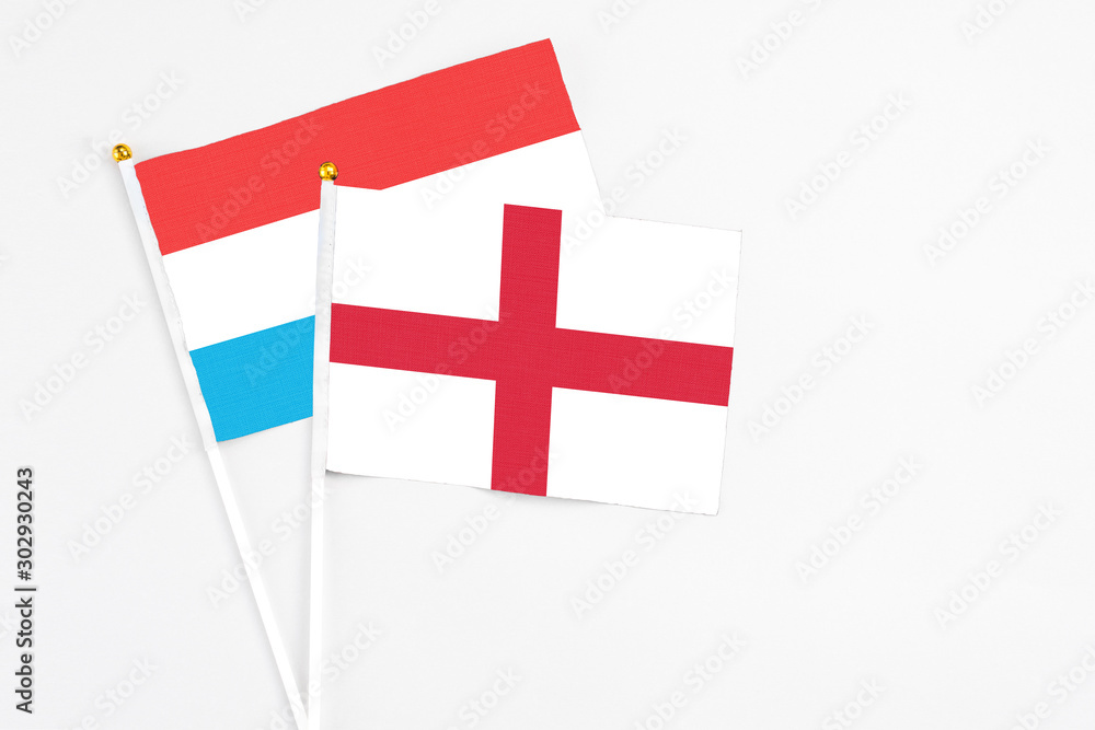 England and Luxembourg stick flags on white background. High quality fabric, miniature national flag. Peaceful global concept.White floor for copy space.